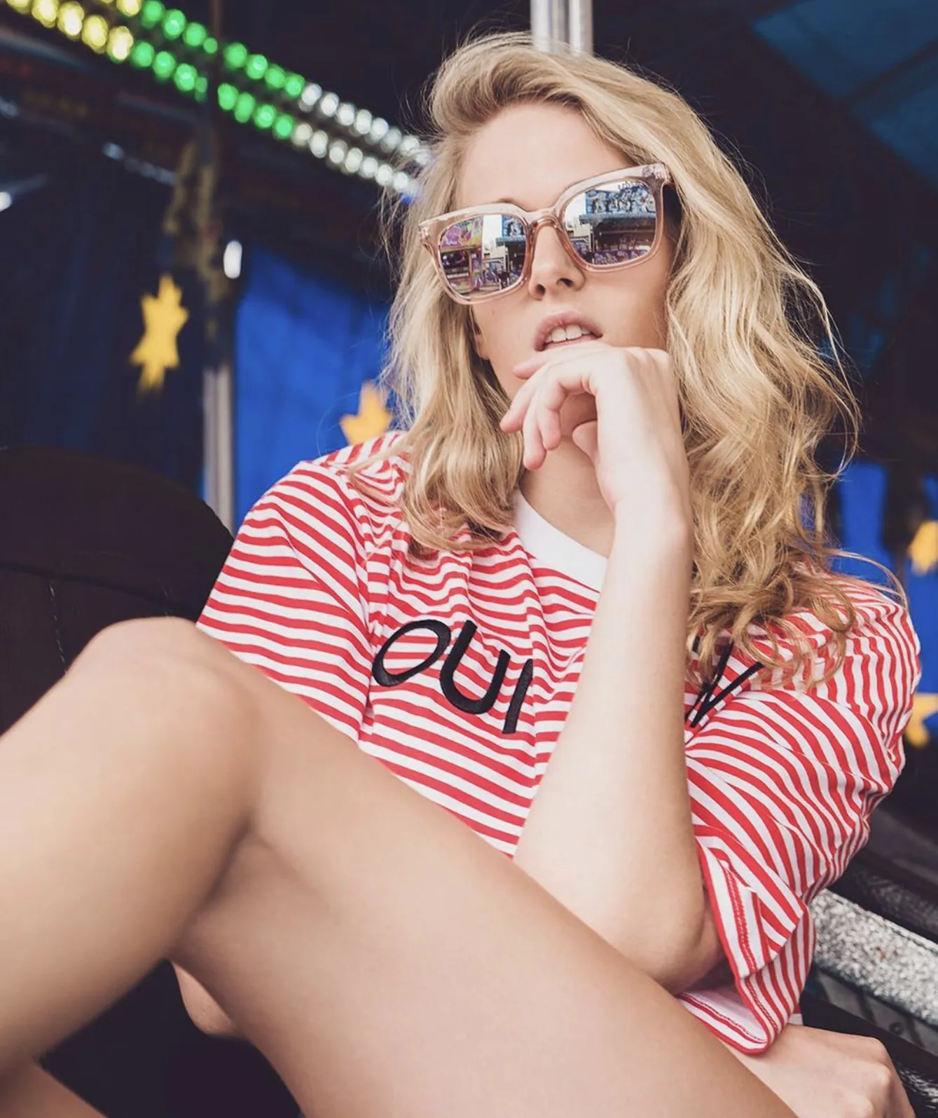 Frau mit Sonnenbrille im Ringelshirt auf dem Rummel