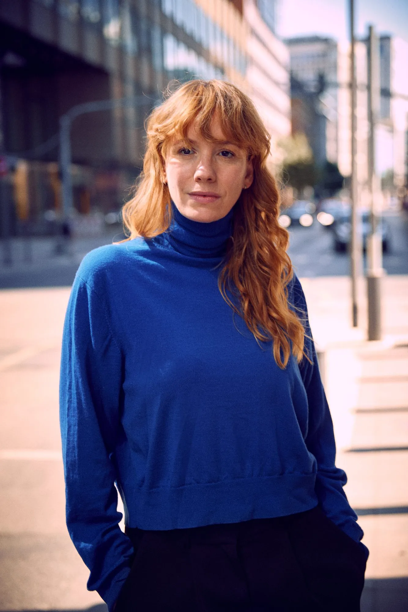 Laura im blauen Rollkragen auf der Straße