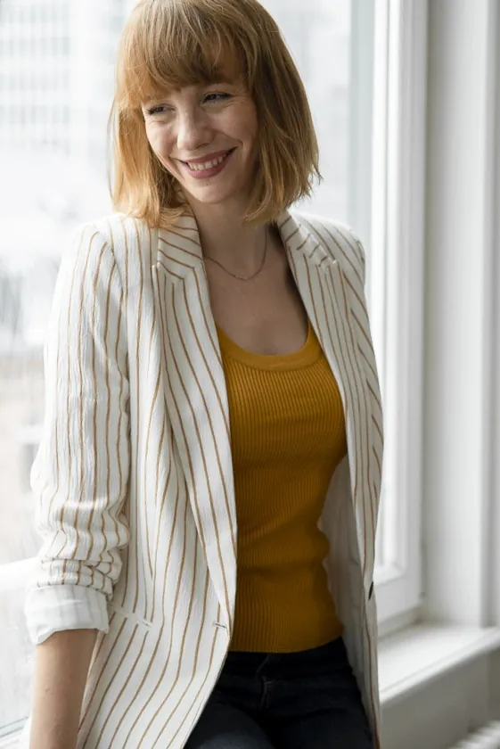 Laura im gestreiften Blazer am Fenster