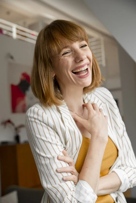 Laura lacht im gestreiften Blazer