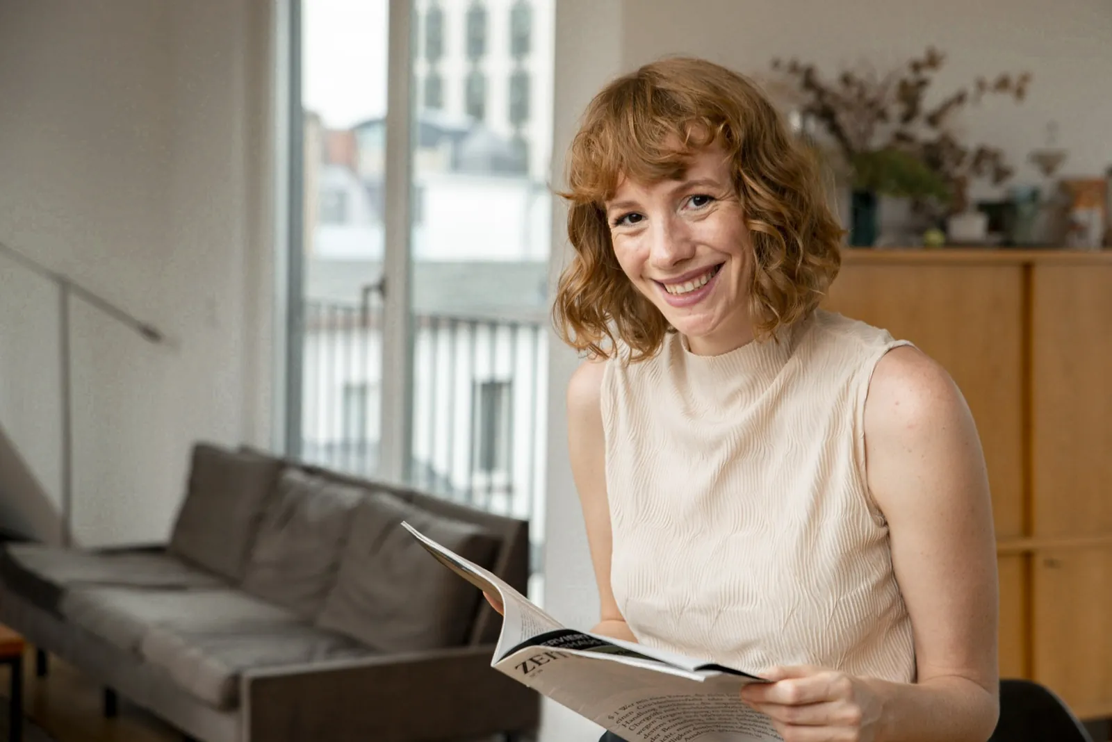 Laura blättert lachend in einer Zeitschrift